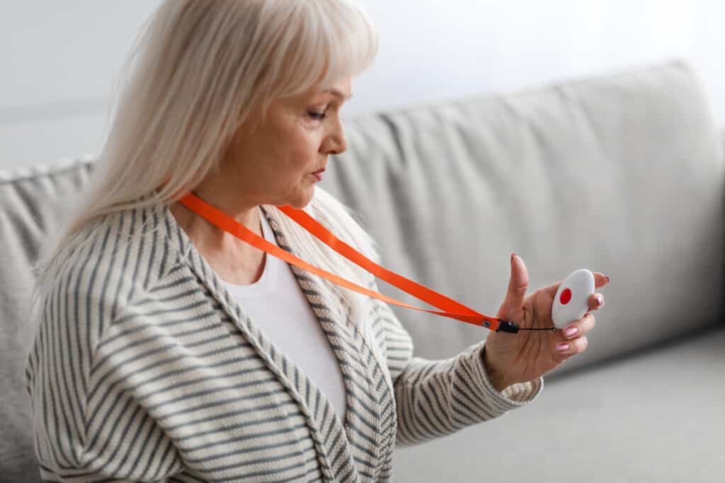 Emergency call system. Senior woman holding Alarm Button