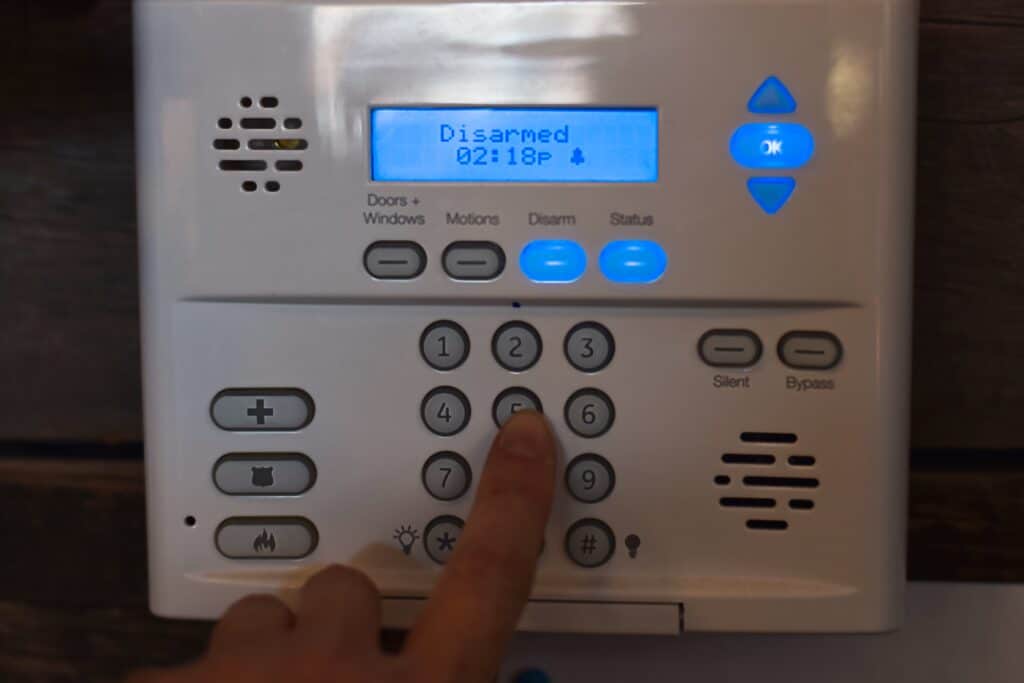 Woman’s finger entering passcode into security alarm system on a wall at a restaurant